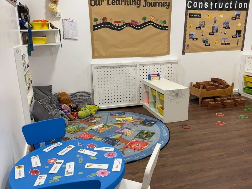 A learning corner in the Golden Kidz Daycare preschool room, with an activity table and a book area